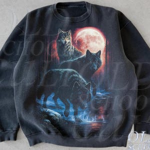 May include: Black sweatshirt featuring a graphic of three wolves in a forest with a red moon. The design includes the text "OLD SCHOOL CULT" and the word "Black" at the bottom. The sweatshirt has a crew neck and long sleeves.