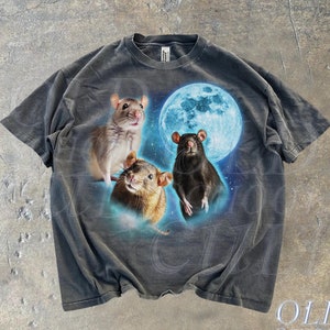 May include: A dark grey t-shirt featuring a graphic print of three rats in front of a blue moon. The rats are brown, grey, and black.