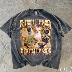 May include: A dark gray t-shirt with a graphic print of pugs and a capybara. The text "PHYSICALLY THICK MENTALLY SICK" is printed in gold letters on the shirt.