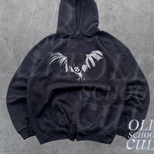 May include: Black hooded sweatshirt with a white graphic of a bat with outstretched wings. The text "OLD SCHOOL CULT" is printed in white at the bottom right corner of the image.