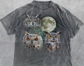 May include: A dark gray t-shirt with a graphic print of three owls and a full moon. The owls have orange eyes and are surrounded by a starry sky. The text "OLD SCHOOL CULT" is printed on the bottom of the shirt.