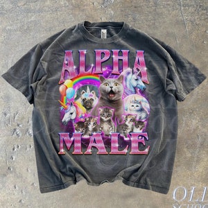 Może przedstawiać: Czarny T-shirt z wyblakłym wyglądem przedstawiający grafikę kota z kociętami i jednorożcami. Tekst "ALPHA MALE" jest nadrukowany różowymi literami.