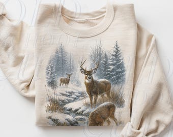 May include: Sand-colored sweatshirt featuring a detailed illustration of deer in a snowy forest scene. The artwork depicts several deer near a stream, surrounded by trees and a misty atmosphere. The sweatshirt has a classic crew neck and long sleeves.