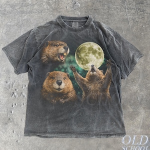 May include: Dark grey t-shirt featuring a graphic of three beavers and a full moon. The beavers are in various poses, with one appearing to be howling at the moon. The shirt has a vintage, distressed look, with the text "OLD SCHOOL CULT" and "Pepper".