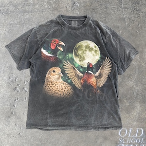 Peut inclure: T-shirt gris foncé avec un motif de trois faisans et une pleine lune. Le t-shirt a un aspect vintage et vieilli. Le texte "OLD SCHOOL CULT" est imprimé en bas à droite du t-shirt.