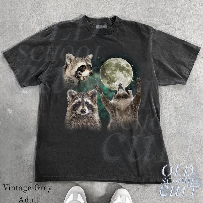 May include: Vintage grey adult t-shirt featuring a graphic of three raccoons with a full moon in a night sky. The shirt has a crew neck and short sleeves. The text "OLD SCHOOL CULT" is printed on the bottom right.