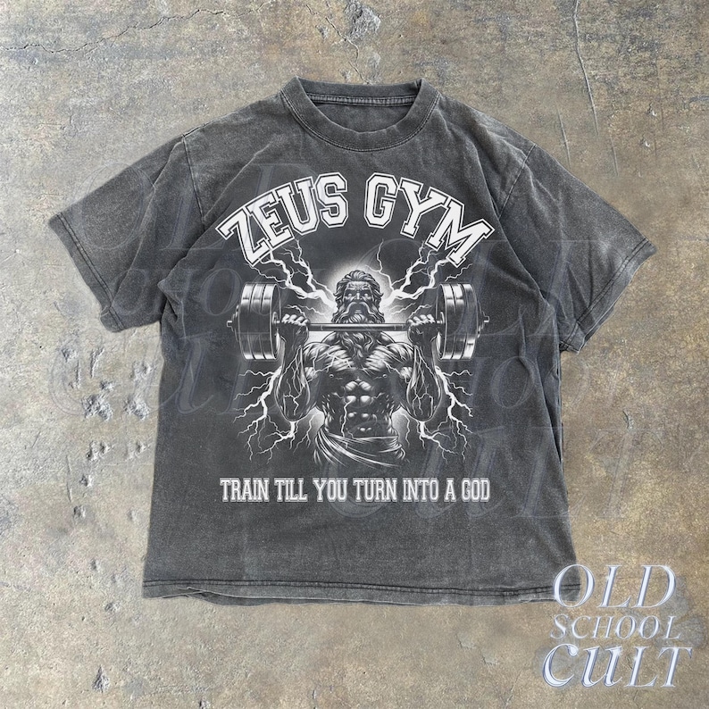 May include: Black t-shirt with a faded look featuring a graphic of Zeus lifting weights with the text "ZEUS GYM" and "TRAIN TILL YOU TURN INTO A GOD".