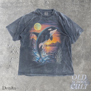 Puede incluir: Camiseta azul denim con un gr&aacute;fico de una orca saltando sobre un fondo de puesta de sol y luna llena. La camiseta tiene un aspecto vintage y descolorido. El texto "OLD SCHOOL CULT" est&aacute; impreso en la parte inferior derecha.