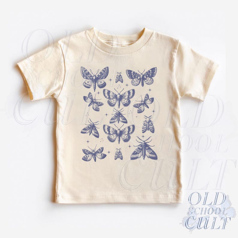 May include: Cream-colored t-shirt featuring a repeating pattern of blue moths and butterflies. The design includes various sizes and styles of the insects, with small star accents. The words "OLD SCHOOL CULT" are printed in blue at the bottom.