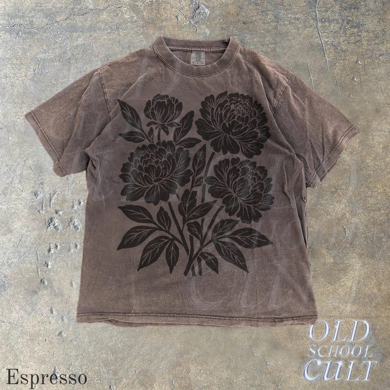 May include: Espresso-coloured t-shirt with a large dark brown floral design. The shirt has a crew neck and short sleeves. The text "OLD SCHOOL CULT" is visible in the lower right corner.