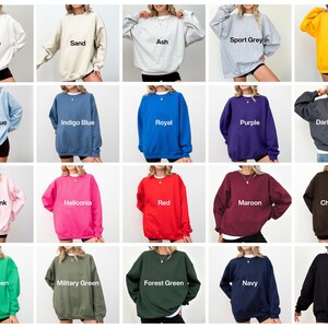May include: A collection of crewneck sweatshirts in various colors, including white, sand, ash, sport grey, gold, light blue, indigo blue, royal, purple, dark heather, light pink, heliconia, red, maroon, chocolate, irish green, military green, forest green, navy, and black.