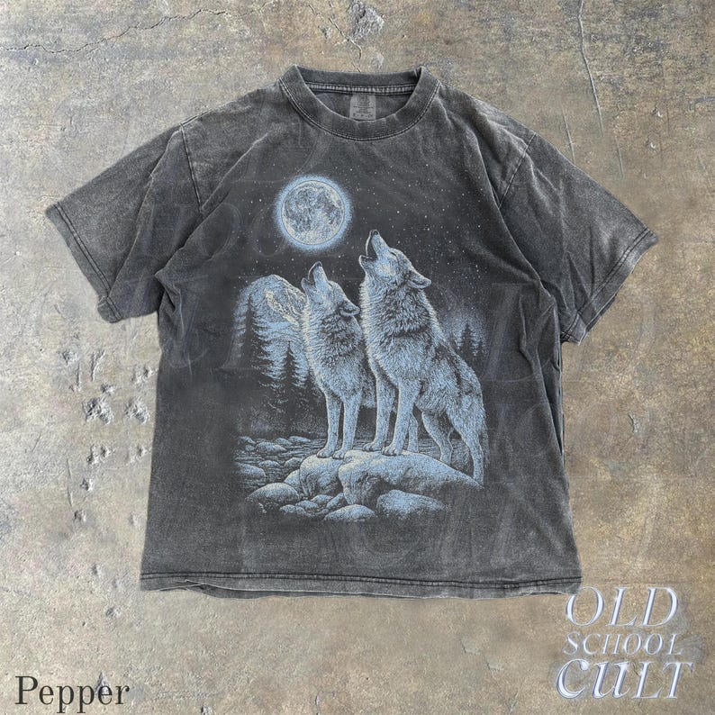 May include: A dark gray t-shirt featuring a graphic of two wolves howling at the moon under a starry night sky. The design includes a mountain range and forest. The word "Pepper" is at the bottom left and "OLD SCHOOL CULT" at the bottom right.