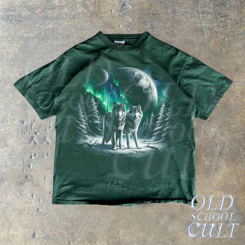 May include: A green t-shirt with a graphic print of two wolves howling at the moon. The wolves are silhouetted against a backdrop of a starry sky and a green aurora borealis.