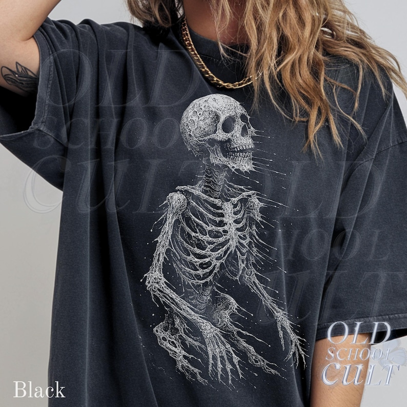 May include: Black t-shirt featuring a detailed white illustration of a human skeleton. The design has a distressed, vintage aesthetic. The text "OLD SCHOOL CULT" is printed on the lower right. The word "Black" is printed on the lower left.