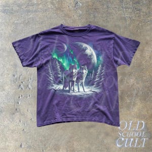 May include: Purple t-shirt with a graphic print of two wolves howling at the moon with a green aurora borealis in the background.