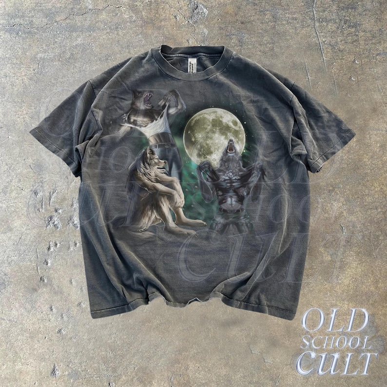 K&ouml;nnte beinhalten: Ein dunkelgraues T-Shirt mit einem Grafikdruck von vier W&ouml;lfen, die zum Mond heulen. Die W&ouml;lfe sind in einem realistischen Stil mit detailliertem Fell und scharfen Z&auml;hnen dargestellt. Der Mond ist ein Vollmond und in hellgrau dargestellt. Das T-Shirt hat einen Rundhalsausschnitt und kurze &Auml;rmel.