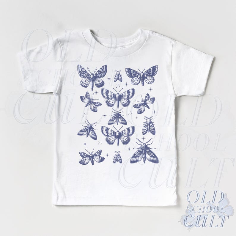 May include: White t-shirt featuring a collection of blue moth illustrations. The moths are in various sizes and poses, creating a detailed and artistic design. The shirt is a classic crew neck style.