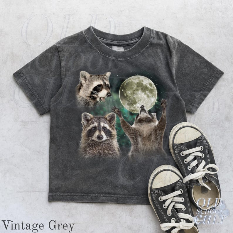 May include: Vintage grey t-shirt featuring a graphic of three raccoons and a full moon. One raccoon is looking up at the moon with its arms raised. The text "OLD SCHOOL CULT" is visible on the right side of the image.