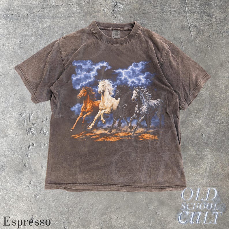 May include: Espresso-colored t-shirt featuring a graphic of four running horses under a blue and white lightning-filled sky. The shirt has a vintage, faded look. The text "OLD SCHOOL CULT" is printed on the bottom right.
