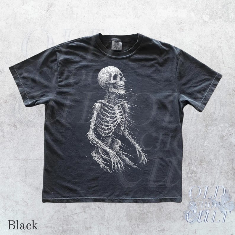 May include: Black t-shirt featuring a detailed white illustration of a human skeleton. The design is centered on the front of the shirt. The words "OLD SCHOOL CULT" are printed in white on the lower right corner. The word "Black" is printed on the lower left corner.