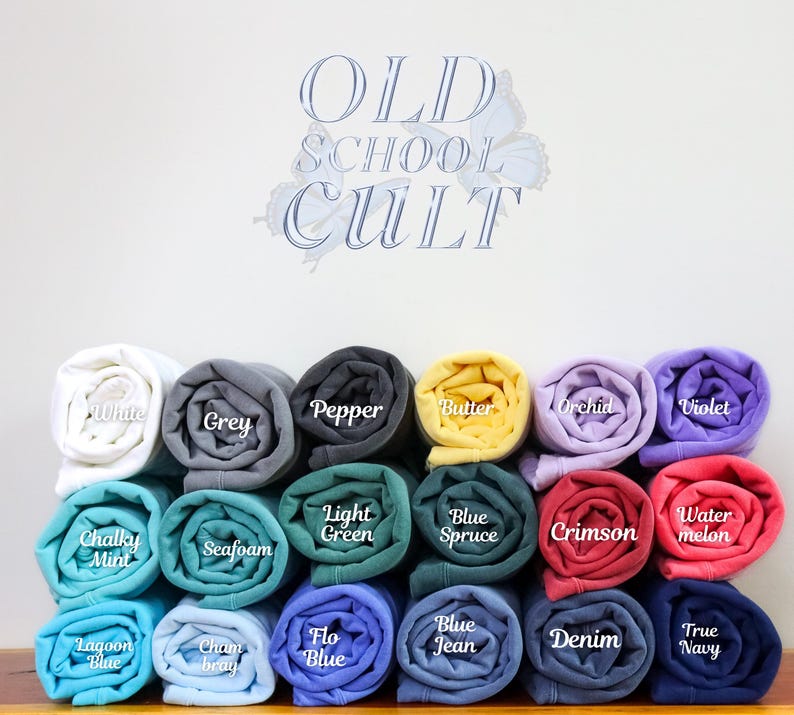 May include: A display of rolled-up fabric in various colors, including white, grey, black, yellow, purple, red, and blue. Each roll is labeled with its color name, such as "White," "Grey," and "Pepper." The text "OLD SCHOOL CULT" is displayed above the rolls.