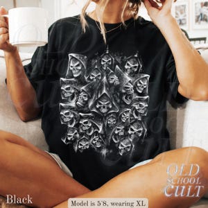 以下が含まれることがあります： 黒いTシャツ。フード付きのローブを着た多数の頭蓋骨の詳細なグラフィックが特徴です。デザインはシャツの中央に配置され、ゴシック様式です。「OLD SCHOOL CULT」の文字がシャツの右下にプリントされています。