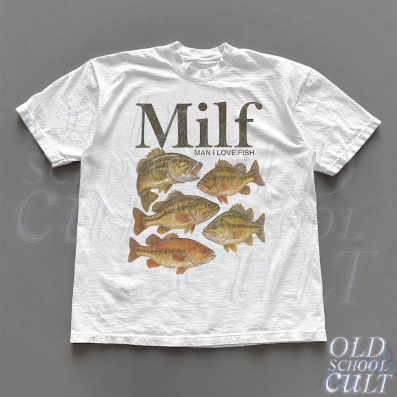 May include: White t-shirt featuring a graphic of six fish in shades of brown and orange. The word "Milf" is printed above the fish, with "Man I Love Fish" below. The shirt has a crew neck and short sleeves.