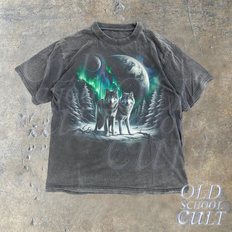 May include: A black t-shirt with a faded graphic print of two wolves standing in a snowy forest under a green aurora borealis. The graphic also includes a planet and a moon.