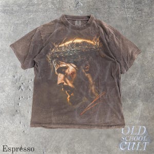 May include: Espresso-colored t-shirt featuring a detailed portrait of a man with a beard and a crown of thorns. The graphic is centered on the front of the shirt. The text "OLD SCHOOL CULT" is visible in the lower right corner.