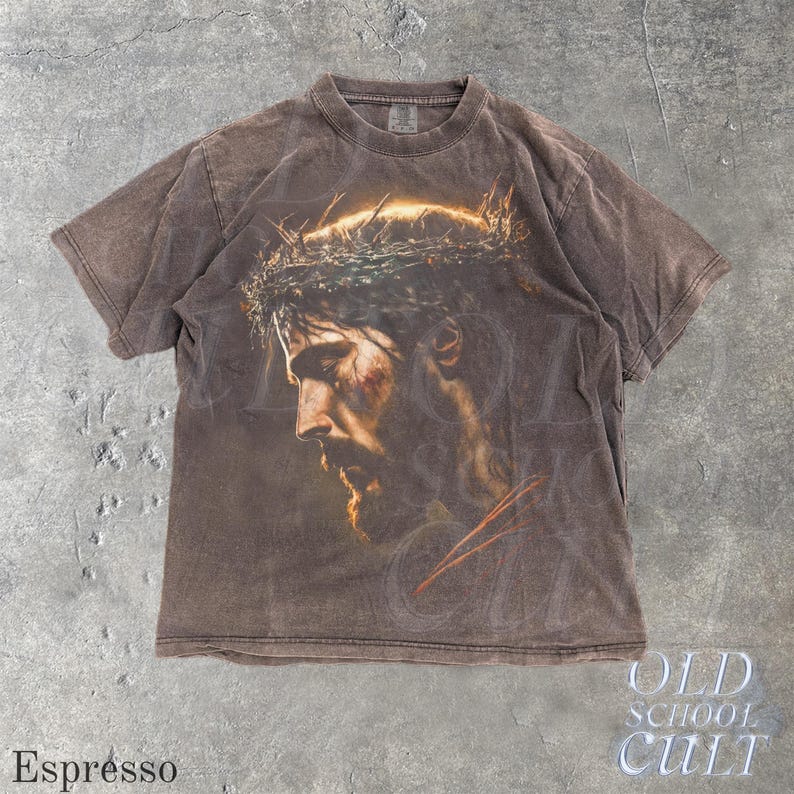 May include: Espresso-colored t-shirt featuring a detailed portrait of a man with a beard and a crown of thorns. The graphic is centered on the front of the shirt. The text "OLD SCHOOL CULT" is visible in the lower right corner.