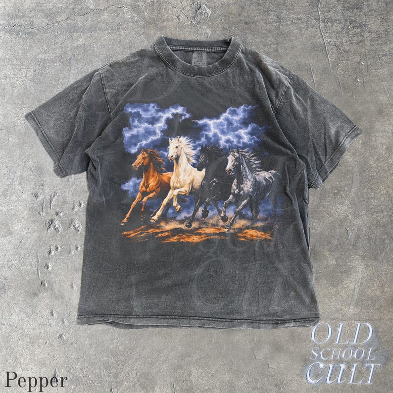 May include: Pepper-colored t-shirt featuring a graphic of four running horses under a stormy sky. The horses are in shades of brown, white, black, and gray. The shirt has a vintage, distressed look, with the text "OLD SCHOOL CULT" on the bottom right.