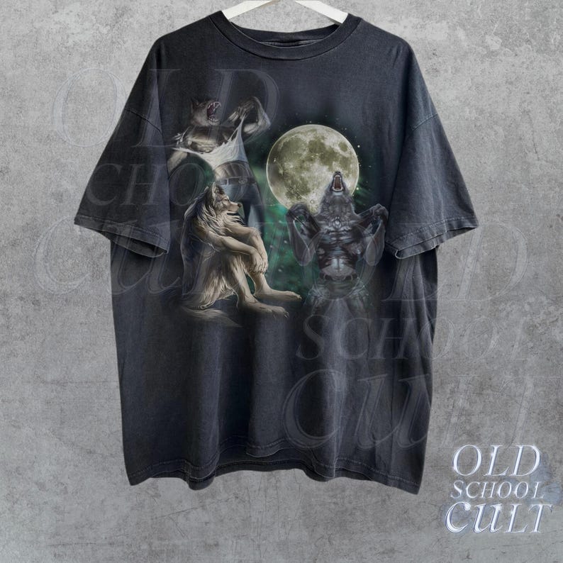 K&ouml;nnte beinhalten: Ein schwarzes T-Shirt mit einem grafischen Druck von drei Werw&ouml;lfen, die zum Mond heulen. Der Mond ist voll und hell, und die Werw&ouml;lfe sind in verschiedenen Posen. Das Shirt ist im Vintage-Stil und hat einen verblassten Look.
