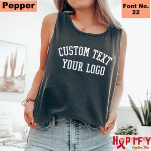May include: A dark gray sleeveless tank top with the text "CUSTOM TEXT YOUR LOGO" in white. The font number is 22.
