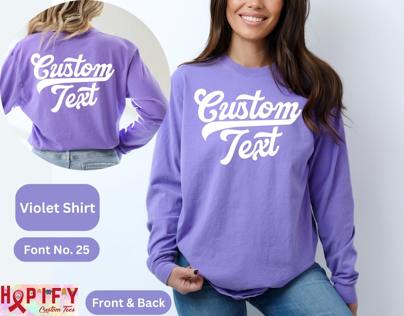 Pode incluir: Uma camisa de manga comprida roxa com o texto "Custom Text" em uma fonte retro branca na frente e nas costas. A camisa &eacute; mostrada em uma modelo.
