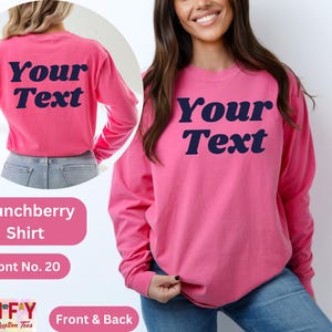 Pode incluir: Camiseta rosa de manga comprida com "Your Text" em uma fonte de estilo retr&ocirc; na frente e nas costas. A camiseta &eacute; feita de um tecido macio e confort&aacute;vel.