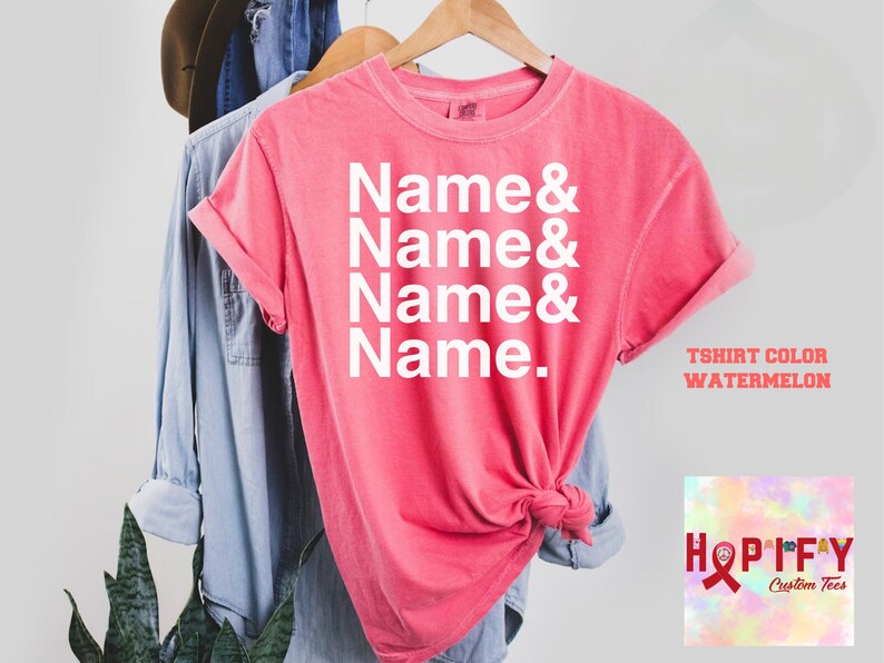 May include: A pink t-shirt with the text "Name & Name & Name & Name." printed in white. The t-shirt is on a hanger and has a knotted front. The text "T-shirt Color Watermelon" is visible in the bottom right corner of the image.