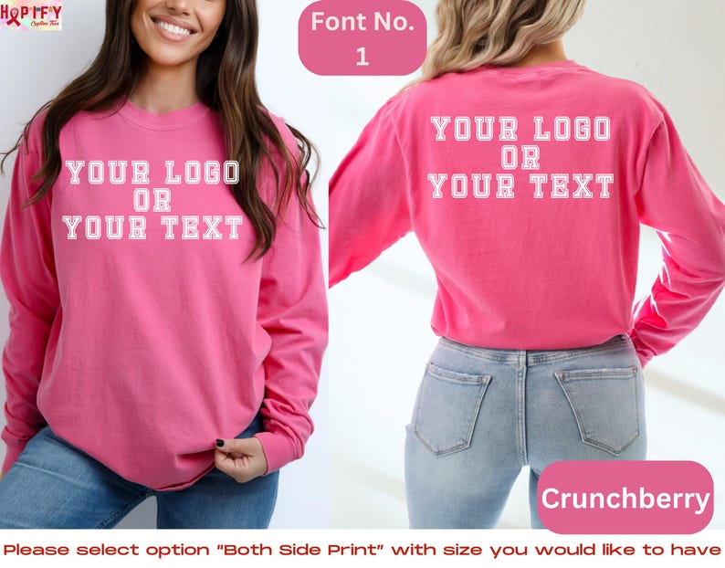 May include: A pink long-sleeved t-shirt with the text "YOUR LOGO OR YOUR TEXT" printed on the front and back. The shirt is shown on a model wearing blue jeans.