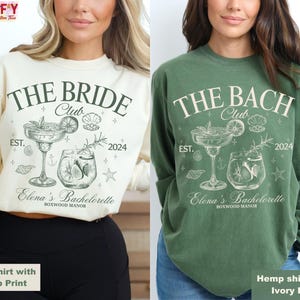 May include: Two long-sleeved shirts with a bachelorette party design. The ivory shirt has a green print that says "The Bride Club" and the green shirt has an ivory print that says "The Bach Club". Both shirts have a cocktail glass with a lime wedge and a star fish design.