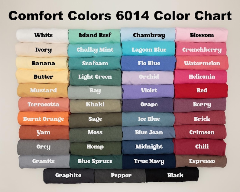 Pode incluir: Carta de cores mostrando 24 cores diferentes de tecido Comfort Colors 6014. As cores est&atilde;o dispostas em duas colunas, com os nomes de cada cor impressos abaixo das amostras de tecido.