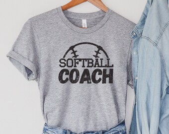 May include: Gray t-shirt with a black softball graphic and the text "SOFTBALL COACH" printed on the front.