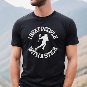 May include: Black t-shirt with a white graphic of a lacrosse player and the text "I beat people with a stick".
