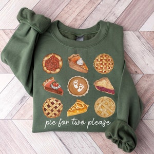 May include: A green sweatshirt with a graphic of various pies and the text "pie for two please".