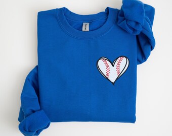 May include: A royal blue sweatshirt with a white heart-shaped baseball graphic on the front.