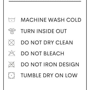 May include: A white rectangular sign with black text providing washing instructions. The sign includes symbols for machine wash cold, turn inside out, do not dry clean, do not bleach, do not iron design, and tumble dry on low. The sign also says "Handmade with love, Please handle with care."