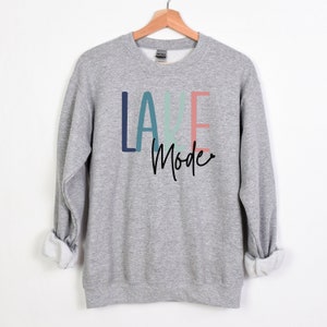 May include: Gray sweatshirt with the text "LAKE Mode" in colorful letters. The letters are in shades of blue, green, and pink.