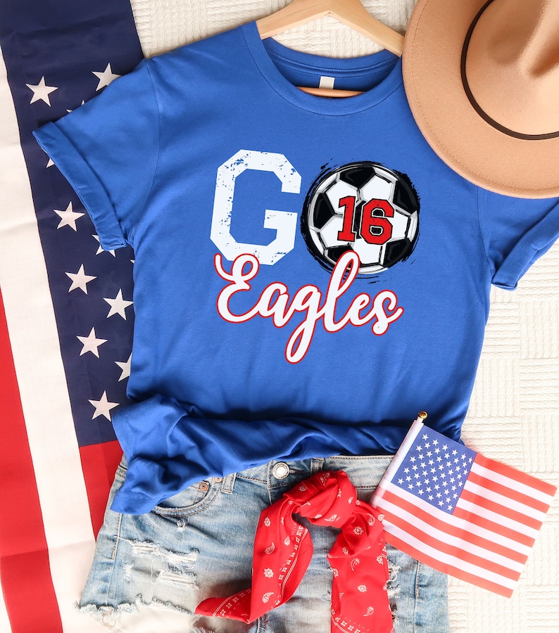 May include: Blue t-shirt with a white "GO" and "Eagles" text and a football with the number 16 on it.