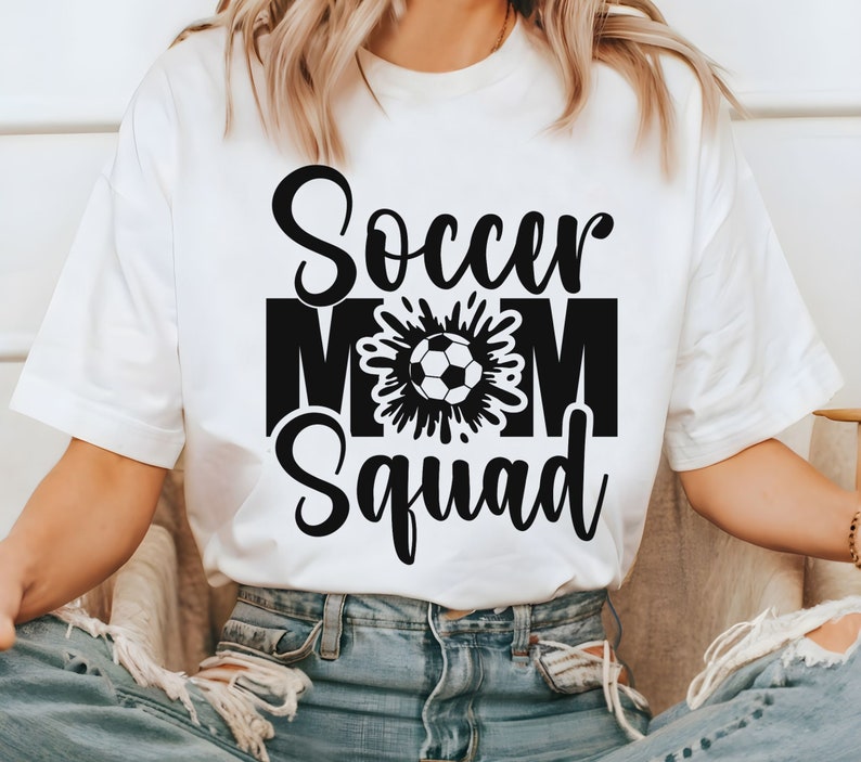 Puede incluir: Camiseta blanca con texto negro que dice "Soccer Mom Squad" y un gr&aacute;fico de bal&oacute;n de f&uacute;tbol en blanco y negro.