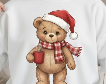 May include: A white sweatshirt with a cartoon teddy bear wearing a red Santa hat and a red and white checked scarf. The bear is holding a red mug. The design is a festive, holiday-themed illustration.