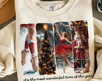 May include: Cream-coloured sweatshirt with a festive design featuring ballet-themed imagery. The design includes a ballerina, a Christmas tree, and a nutcracker, with the text "it's the most wonderful time of the year."