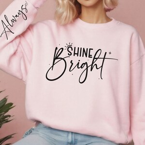 Może przedstawiać: R&oacute;żowa bluza z napisem "Always" na rękawie i "Shine Bright" z przodu.